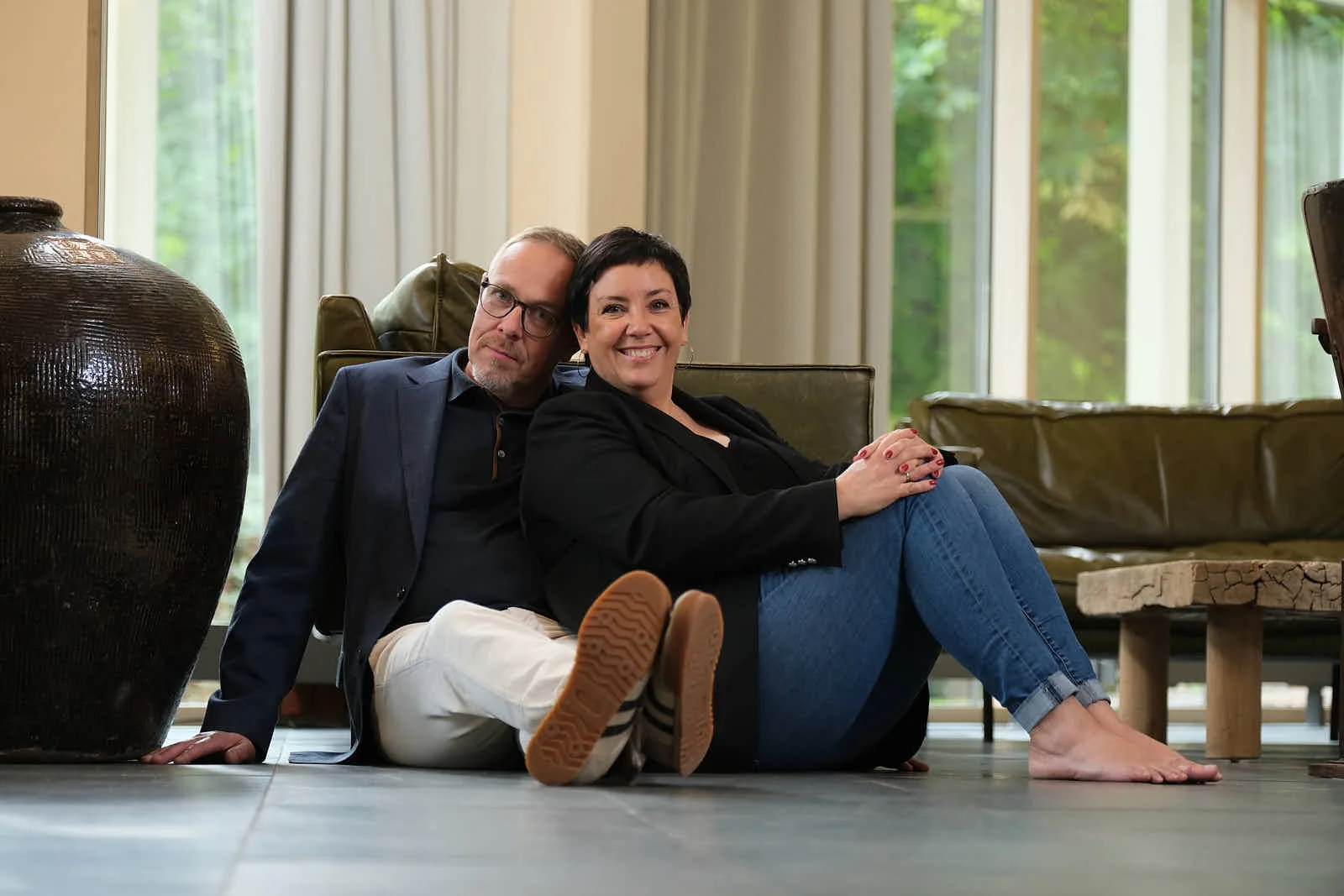 Wiebke und Ingo Anton sitzen entspannt auf dem Boden ihrer Praxis